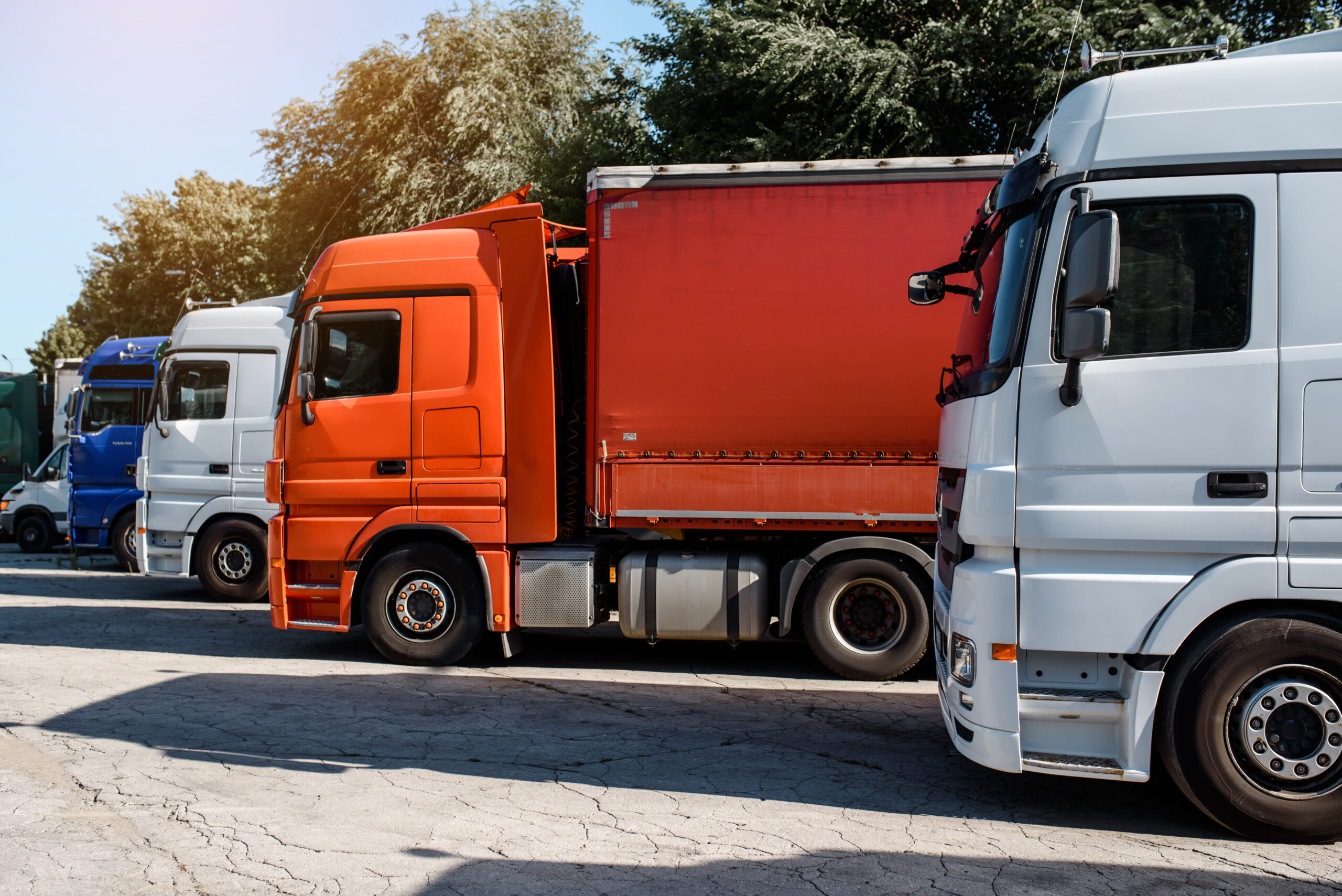 Lateral view of trucks staying in the truck parking on the sunset.